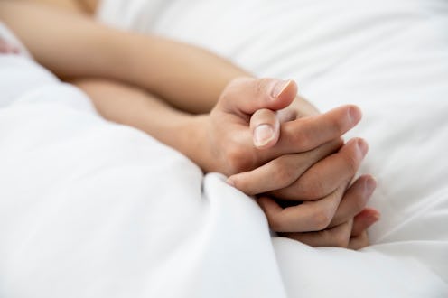Love emotion concept: hand of couple love on the white bed