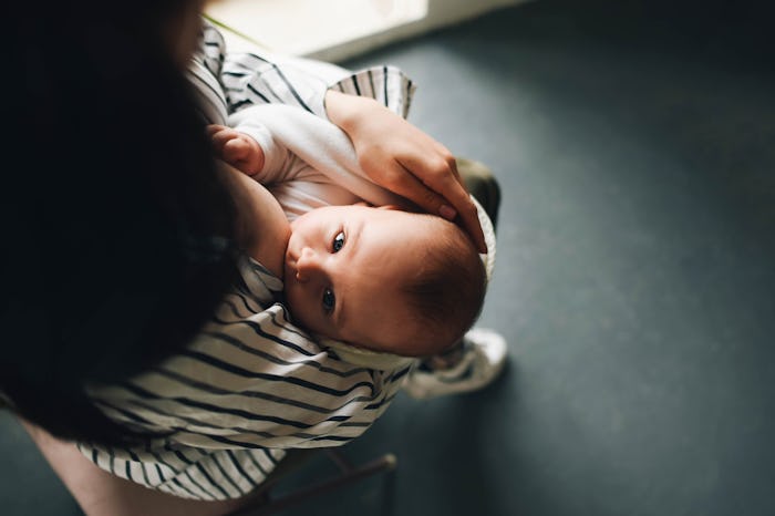 A young mother is breastfeeding her baby. Feeding the baby.