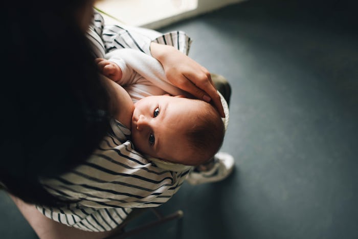 A young mother is breastfeeding her baby. Feeding the baby.