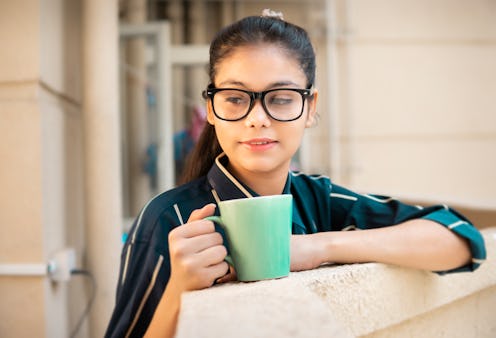 Outdoor image of the beautiful businesswoman in formals with eyeglasses standing in office balcony a...