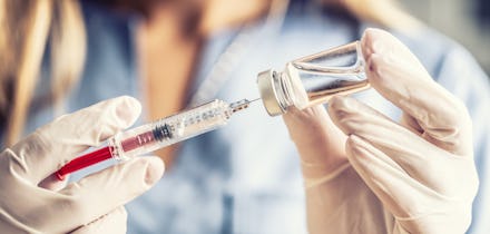 Doctor or nurse in a laboratory preparing a vaccine for a patient.