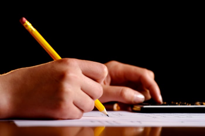 Close-up of hands with a pen and calculator on some document.