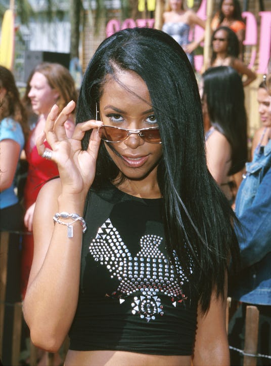 Aaliyah holding her glasses down and looking over them