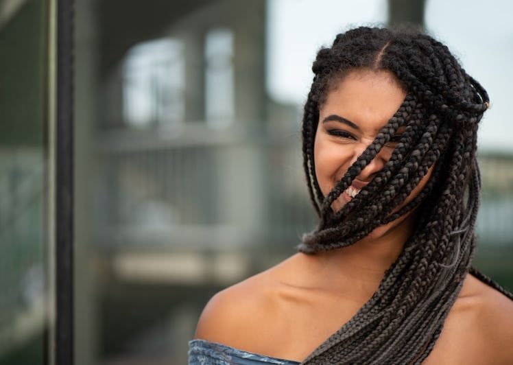 Trendy american african teen with hair braids covering her face