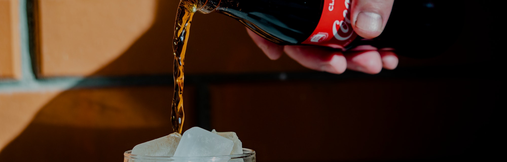 UKRAINE - 2021/04/29: In this photo illustration a Coca-Cola soft drink being poured into a glass wi...