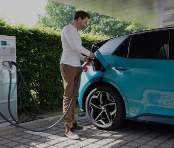 08 June 2021, Saxony, Dresden: A man plugs a charging cable into the filler neck of a VW ID.3 during...