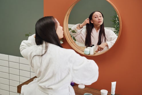 woman brushing her hair in front of the mirror