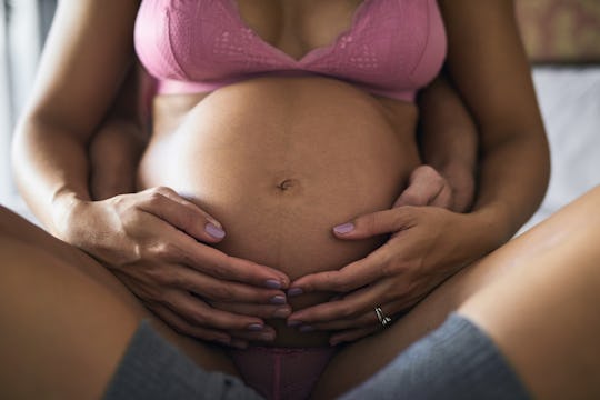 Cropped shot of a unrecognizable young man loving his pregnant wife in their bedroom