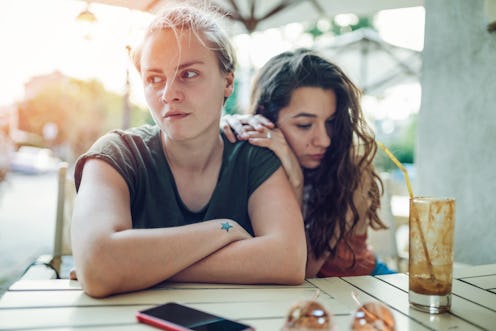 A young couple sits in silence at a café. These are four signs of resentment in relationships.