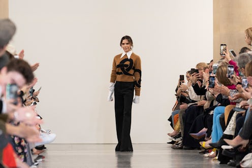 Victoria Beckham on stage following the runway presentation of a new fashion collection. She is stan...
