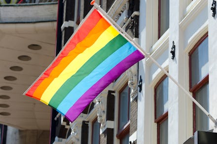 A clean rainbow flag hanging out of a building.