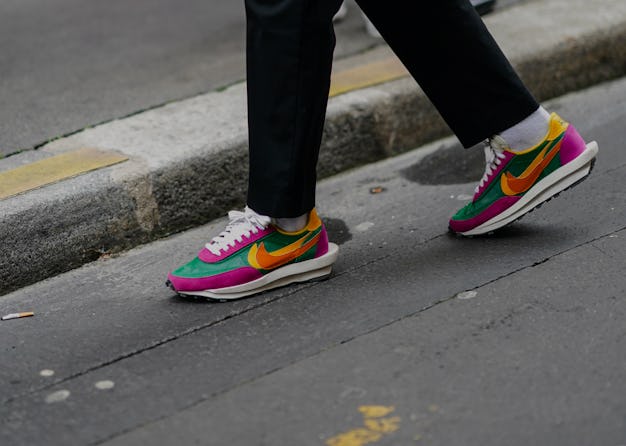 PARIS, FRANCE - JANUARY 15: A guest wears black pants, white socks, multicolor Nike sneakers, outsid...