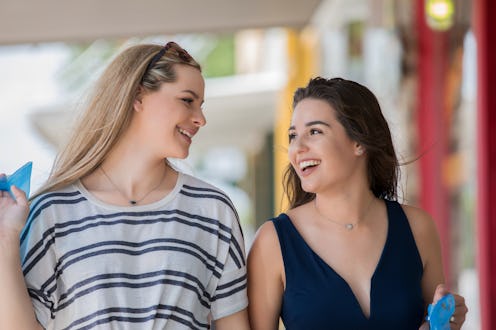 Two young females laughing while walking together