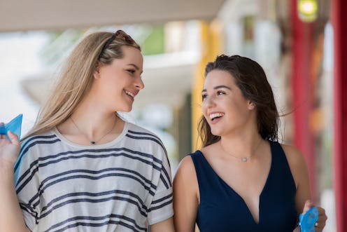 Two young females laughing while walking together