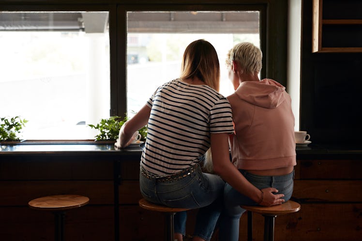 Two girlfriends, with one holding the other's butt.