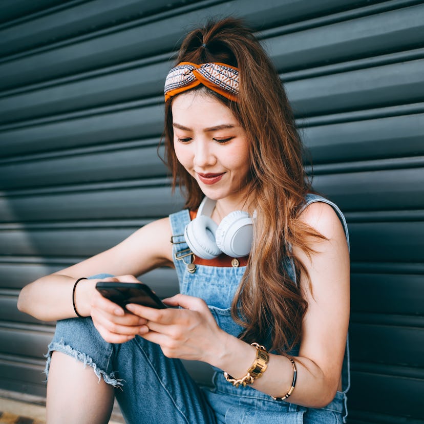 Smiling student wearing headphones around her neck, checking how the July 2021 new moon will affect ...