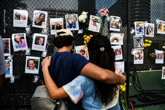 TOPSHOT - People visit the makeshift memorial for the victims of the building collapse, near the sit...