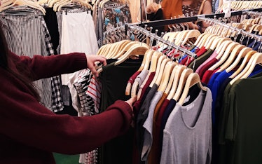 A person looking through clothing racks at a store