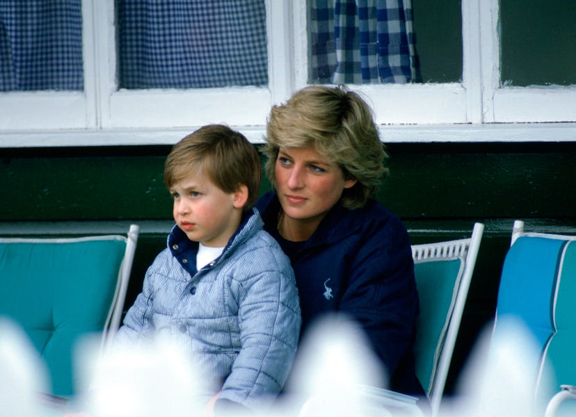 Prince William sits on his mom's lap.