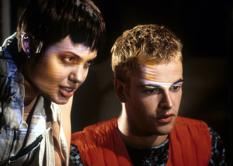 Angelina Jolie stands behind Jonny Lee Miller in a scene from the film 'Hackers', 1995. (Photo by Un...