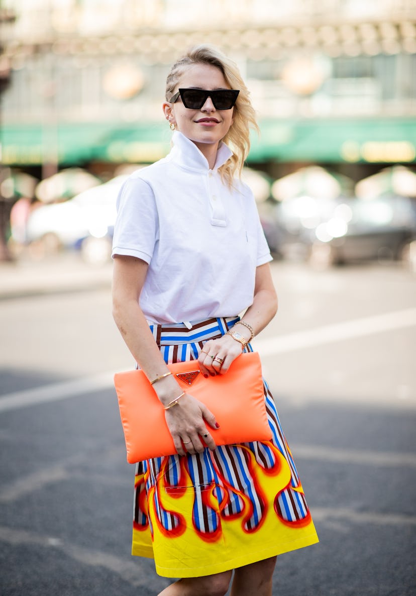 PARIS, FRANCE - JULY 02: Caroline Daur wearing orange Prada bag, white polo shirt, skirt with fire p...