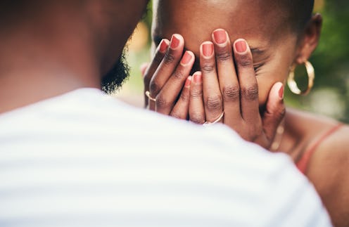 Cropped shot of young woman covering her eyes while standing with her husband