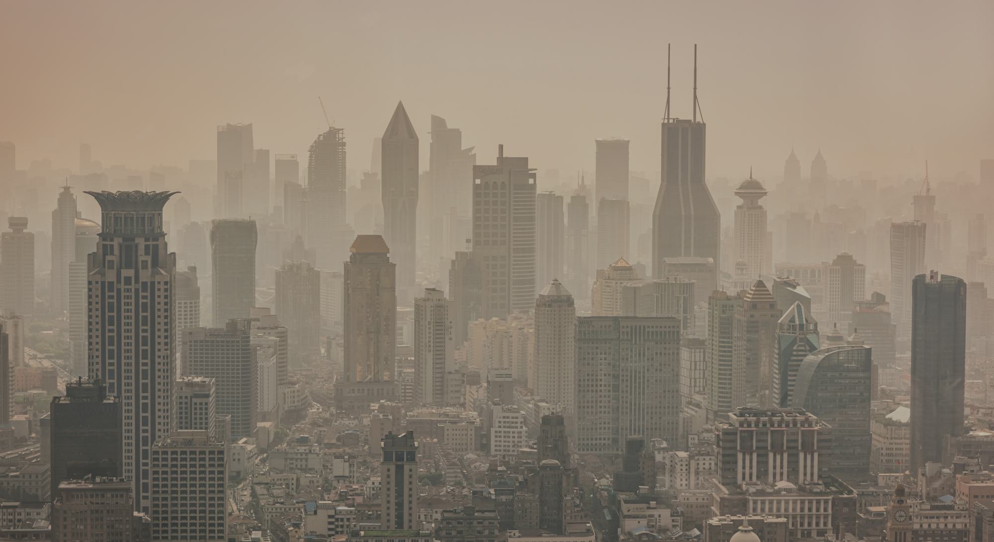 Shanghai foggy modern skyscraper cityscape in early morning light. View from above over the Megacity...