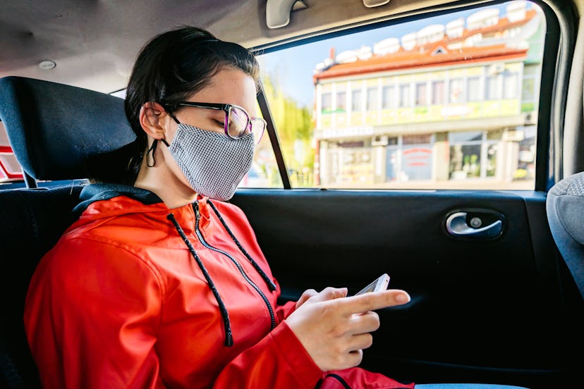 A woman looks at her phone wearing a mask, about to have a panic attack. Why do i sweat when i'm col...