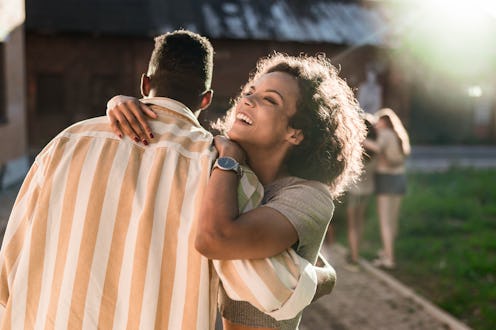 Happy black couple having fun while embracing on the street.