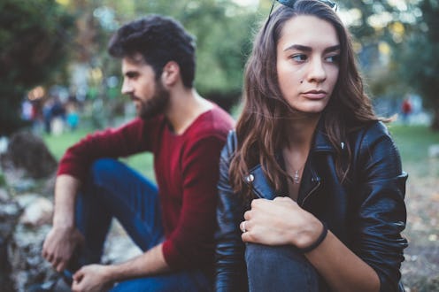 Young couple in the park feeling unhappy