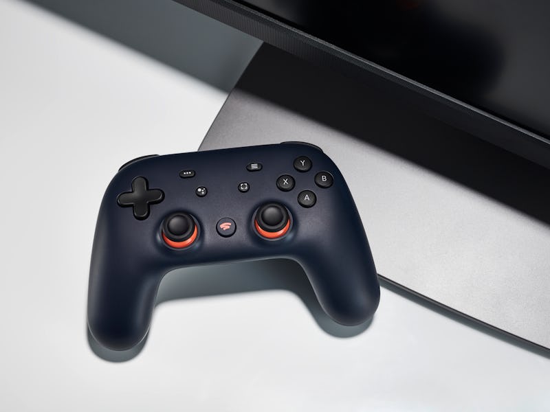 A Google Stadia video game controller with a Night Blue finish alongside a gaming monitor, taken on ...