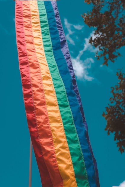 A long pride flag flies against a blue sky. Here's why rainbows are associated with LGBTQ+ Pride. 