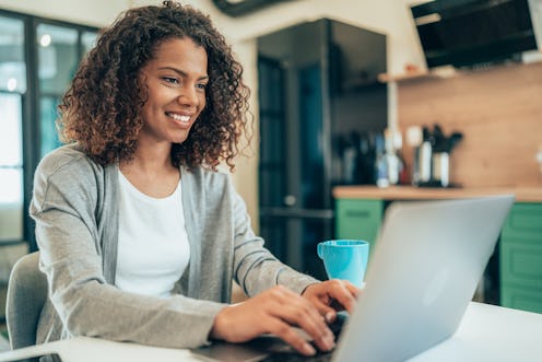 Beautiful afro-american woman using laptop at home