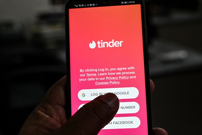 In this photo illustration taken on October 6, 2020, a user checks the dating app Tinder on a mobile...