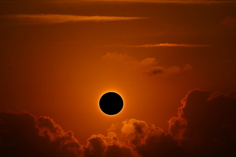 A solar eclipse against clouds. Is it safe to go outside during an eclipse? 