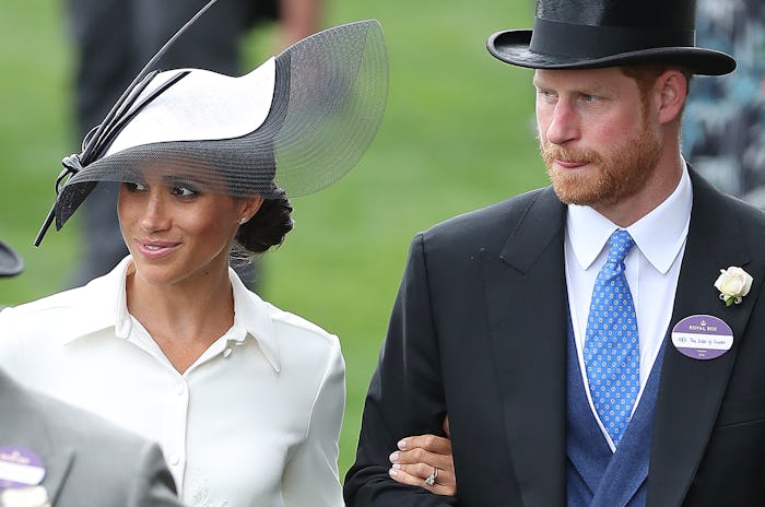 Britain's Prince Harry, Duke of Sussex (R) and his wife Britain's Meghan, Duchess of Sussex attend d...