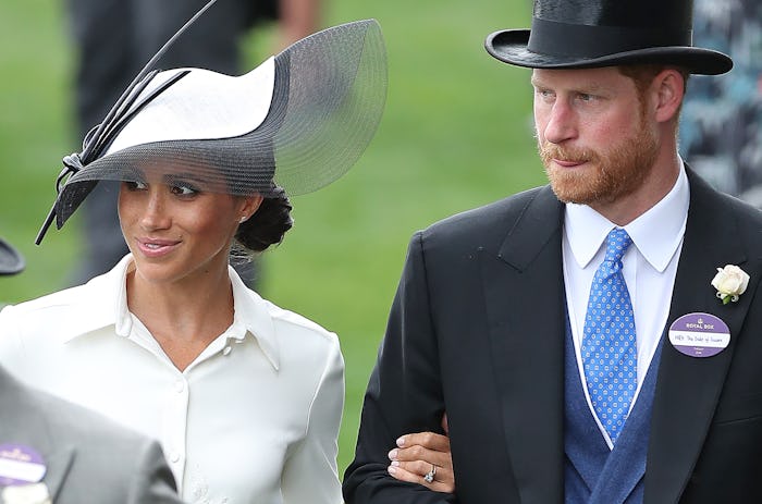 Britain's Prince Harry, Duke of Sussex (R) and his wife Britain's Meghan, Duchess of Sussex attend d...