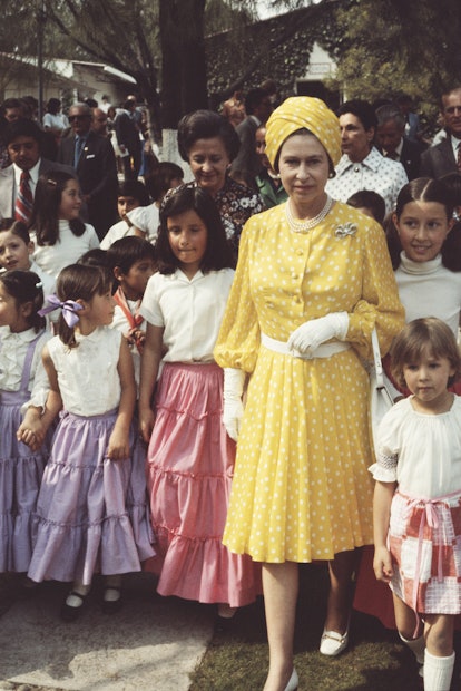 Queen Elizabeth II with a group of local children during her state visit to Mexico, February-March 1...