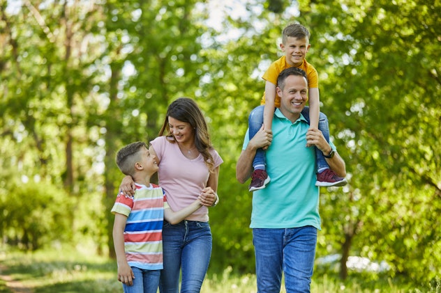 Family of four walking through the park