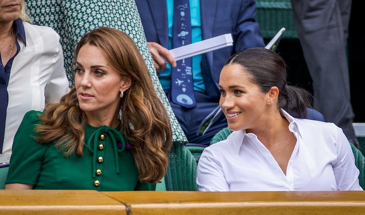 Catherine, Duchess of Cambridge sits with Meghan, Duchess of Sussex in the Royal Box on Centre Court...