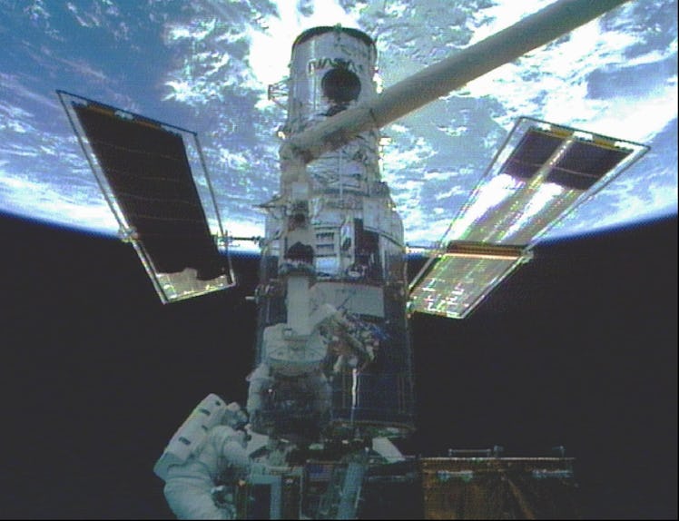 Discovery astronauts Steven Smith, lower left, and Mark Lee work on the Hubble Space Telescope in th...