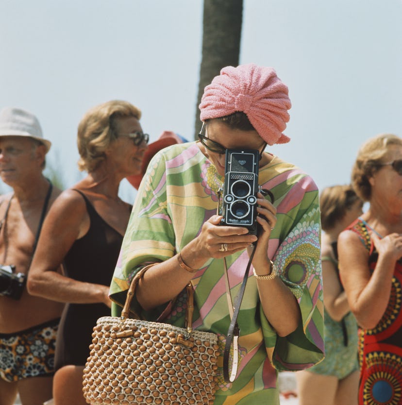 Princess Grace of Monaco taking a photograph at a swimming competition at Monte Carlo. 