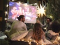 Friends making movie night in their backyard to show what to bring to an outdoor movie.