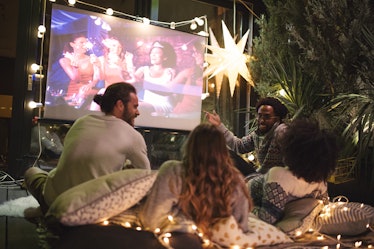 Friends making movie night in their backyard to show what to bring to an outdoor movie.