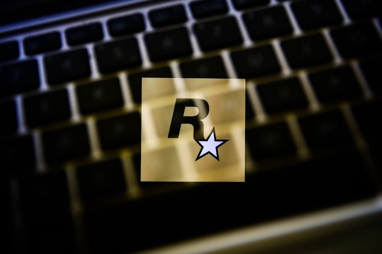 Rockstar Games logo displayed on a phone screen and a keyboard are seen in this multiple exposure il...