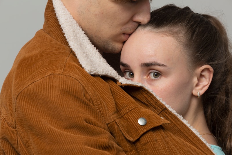 woman covering her face with a man's jacket