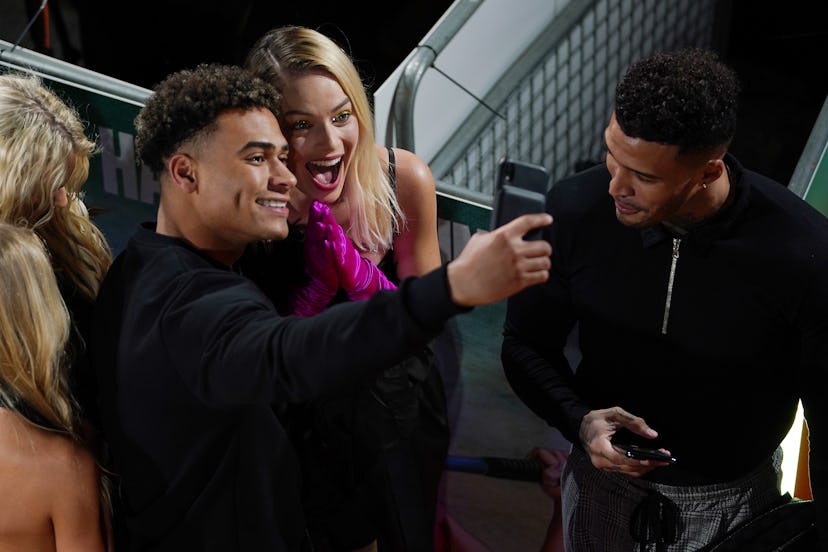 LONDON, ENGLAND - JANUARY 29: Margot Robbie poses for selfies with Love Island contestants at the "B...