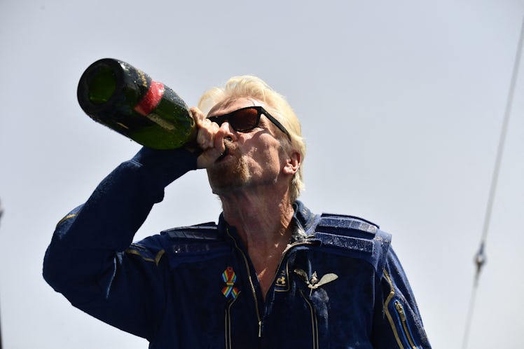 Virgin Galactic founder Sir Richard Branson, drinks champagne with crew members after flying into sp...