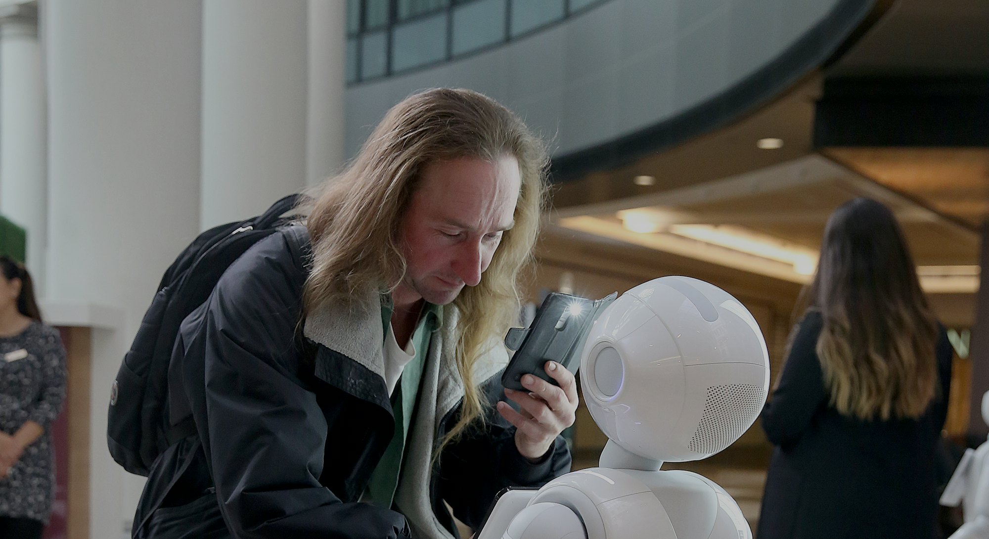 Paul Bartholomew interacts with Pepper, a robot by SoftBank Robotics, which will greet and play game...