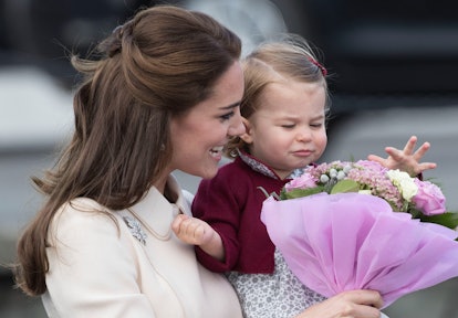Princess Charlotte inspects a bouquet of flowers with her mom. 